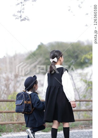 桜と入園式を迎えた3歳の女の子と9歳の姉 桜と入園式を迎えた3歳の女の子と9歳の姉 126360380