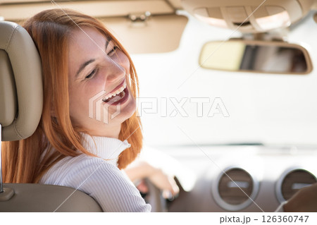 Young redhead woman driver driving a car smiling happily. Young redhead woman driver driving a car smiling happily. 126360747