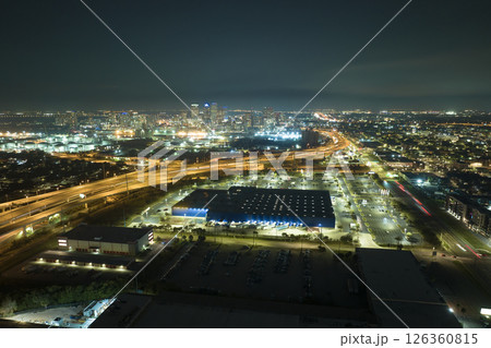 View from above of many parked cars on illuminaded parking lot at night in front of a superstore. Place for vehicles in front of a shopping mall center View from above of many parked cars on illuminaded parking lot at night in front of a superstore. Place for vehicles in front of a shopping mall center 126360815