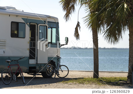 USA travel by motorhome. Camping vehicle parked on ocean shore in sunny Florida. Travel infrastructure. USA travel by motorhome. Camping vehicle parked on ocean shore in sunny Florida. Travel infrastructure. 126360829