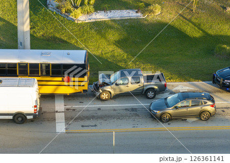Traffic accident on American street in Florida. First responders helping victims of school bus and car crash on road in USA. Aerial view of emergency services responding to accident site Traffic accident on American street in Florida. First responders helping victims of school bus and car crash on road in USA. Aerial view of emergency services responding to accident site 126361141