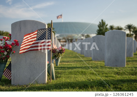 Sarasota National Cemetery with many white headstones with USA flags and flowers on green grass lawn. Memorial Day concept Sarasota National Cemetery with many white headstones with USA flags and flowers on green grass lawn. Memorial Day concept 126361245