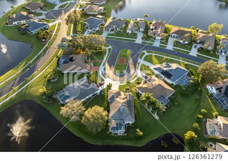 Residential homes at sunset in suburban sprawl development in North Port, Florida. Low-density private houses in rural suburbs. Housing market in the USA Residential homes at sunset in suburban sprawl development in North Port, Florida. Low-density private houses in rural suburbs. Housing market in the USA 126361279