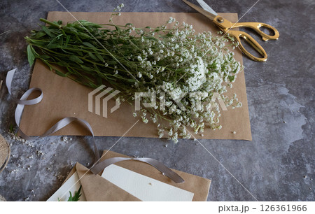 Crafting with natural elements using freshly picked flowers in a creative workspace Crafting with natural elements using freshly picked flowers in a creative workspace 126361966