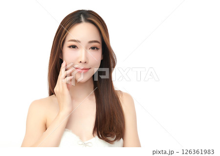 A beautiful young Asian woman with clean, fresh skin against a white background. Skincare, facial treatment, cosmetology, beauty, and spa. An elegant portrait of an Asian woman. 126361983
