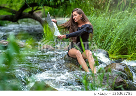worried woman pulls out of water laptop that fell into river, remote holiday work accident worried woman pulls out of water laptop that fell into river, remote holiday work accident 126362783