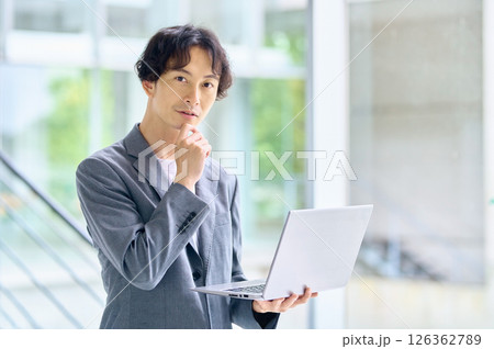 オフィスでパソコンを操作するビジネスカジュアルの男性エンジニア 126362789