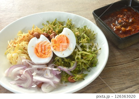 spicy and sour slice wing bean and banana blossom with chop pork sauce topping boiled egg Thai salad on plate 126363020