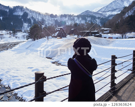 冬の岐阜県の観光名所白川郷の合掌造りと女性観光客の風景 126363624