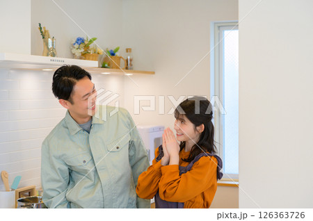 キッチンで並ぶ作業服の日本人男性と主婦の女性 キッチンで並ぶ作業服の日本人男性と主婦の女性 126363726