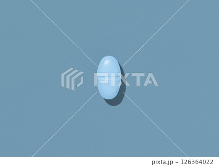 Oval blue Medical pill on blue top view, hard shadows. Preventive medicine and healthcare Oval blue Medical pill on blue top view, hard shadows. Preventive medicine and healthcare 126364022
