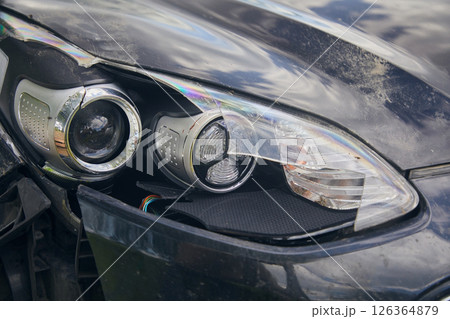 Broken headlight of a black car, close-up Broken headlight of a black car, close-up 126364879