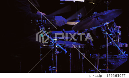 Close-up of a black drum kit on a dark stage. A drummer playing a drum concerto. 126365975