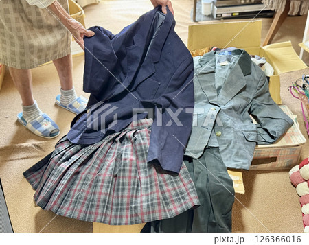 女子学生の制服を持つ高齢女性の手 126366016