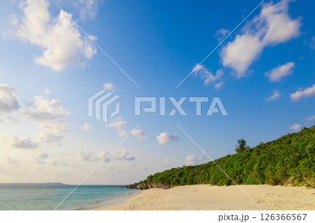 サンセット近づく夕日と青空と青い海、波が美しい宮古島の長間浜のビーチ・砂浜でバカンス(沖縄県宮古島市 サンセット近づく夕日と青空と青い海、波が美しい宮古島の長間浜のビーチ・砂浜でバカンス(沖縄県宮古島市 126366567