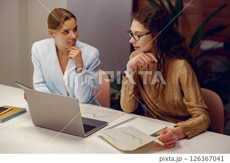 A Business Meeting Taking Place Between Two Professional Women in a Modern Office Environment 126367041