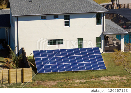 Photovoltaic panels on elevated frame on house backyard for generating of clean electricity 126367138