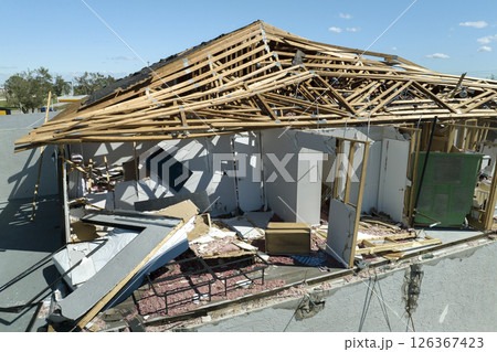 Hurricane Ian destroyed house roof and walls in Florida residential area. Natural disaster and its consequences Hurricane Ian destroyed house roof and walls in Florida residential area. Natural disaster and its consequences 126367423