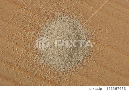 Top View of Granulated Yeast Scattered on Table. 126367458