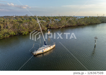 Half sunken sailing yacht capsized on shallow bay waters after hurricane Ian in Manasota, Florida Half sunken sailing yacht capsized on shallow bay waters after hurricane Ian in Manasota, Florida 126367509