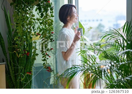 観葉植物に囲まれてリラックスする女性 観葉植物に囲まれてリラックスする女性 126367510