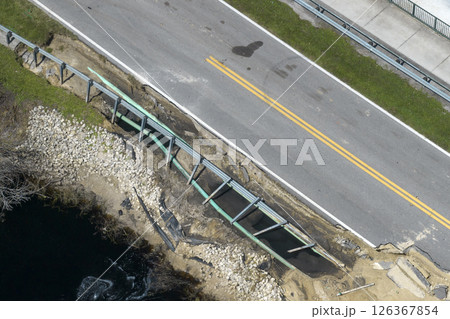 Destroyed bridge after hurricane flooding in Florida. Construction roadwork site. Reconstruction of damaged road after flood water washed away asphalt Destroyed bridge after hurricane flooding in Florida. Construction roadwork site. Reconstruction of damaged road after flood water washed away asphalt 126367854