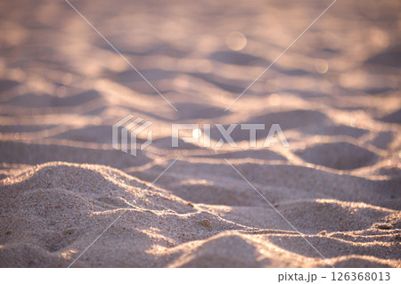 Close up of clean yellow sand surface covering seaside beach illuminated with evening light. Travel and vacations concept 126368013