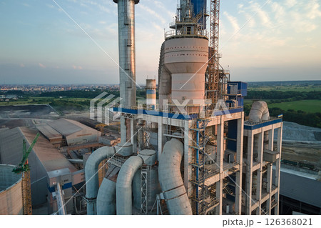 Cement plant with high factory structure and tower cranes at industrial production area. Manufacture and global industry concept Cement plant with high factory structure and tower cranes at industrial production area. Manufacture and global industry concept 126368021