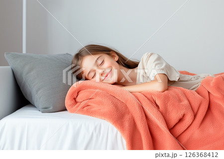 A young girl is sleeping with a blanket and pillow 126368412