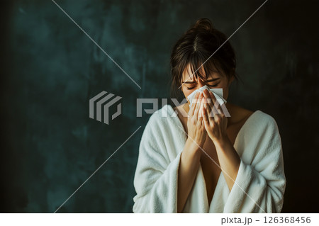 A woman is wiping her nose with a tissue 126368456
