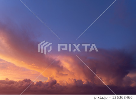 Bright sunset with setting sun behind vivid orange and yellow clouds 126368466