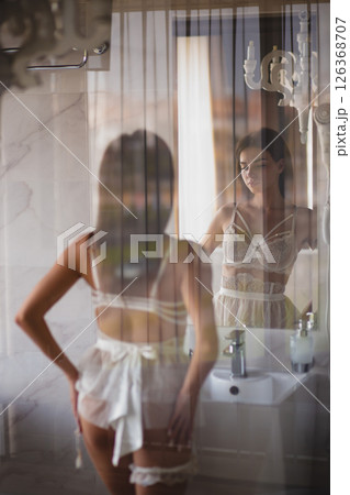 Seductive slender bride in a sexy lingerie posing in a bathroom Seductive slender bride in a sexy lingerie posing in a bathroom 126368707