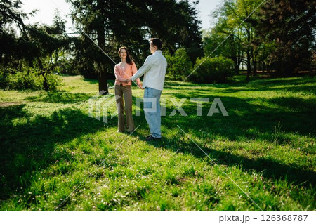 Couple enjoys a joyful moment together in a sunny green park 126368787