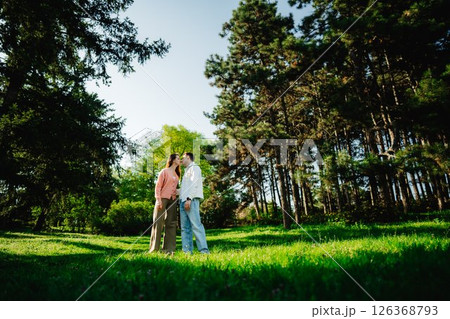 Couple sharing a tender moment in a serene forest clearing at sunset Couple sharing a tender moment in a serene forest clearing at sunset 126368793