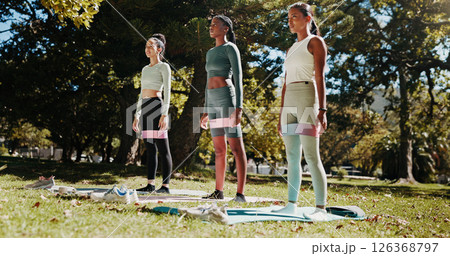 Friends, yoga and women on mat in park for workout, exercise and practice for mobility in morning. Nature, pilates class and people with resistance band for wellness, health and wellbeing on grass 126368797