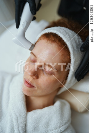 Woman receiving skincare treatment in a serene spa setting 126368865