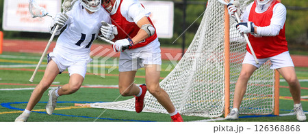 Exciting Lacrosse Match with Defender Holding off Attacker in front of Goalie 126368868
