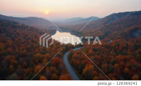 an impressive autumn landscape, forest and mountains against the sunset, a road to the horizon and a lake, sunlight through clouds, beautiful nature an impressive autumn landscape, forest and mountains against the sunset, a road to the horizon and a lake, sunlight through clouds, beautiful nature 126369241