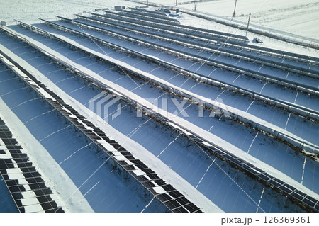 Aerial view of snow melting from covered solar photovoltaic panels at sustainable electric power plant for producing clean electrical energy. Low effectivity of renewable electricity in winter Aerial view of snow melting from covered solar photovoltaic panels at sustainable electric power plant for producing clean electrical energy. Low effectivity of renewable electricity in winter 126369361