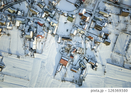 Aerial view of residential houses with snow covered roofops in suburban rural town area in winter Aerial view of residential houses with snow covered roofops in suburban rural town area in winter 126369380