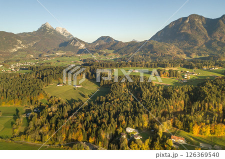 Aerial view of green meadows with villages and forest in austrian Alps mountains. Aerial view of green meadows with villages and forest in austrian Alps mountains. 126369540