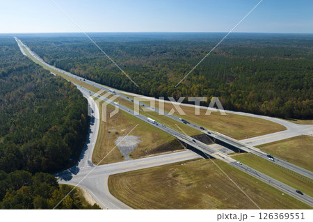 Aerial view of freeway overpass junction with fast moving traffic cars and trucks in american rural area. Interstate transportation infrastructure in USA 126369551
