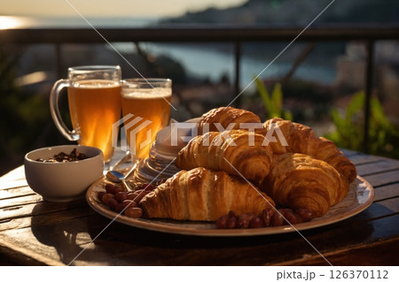 cup of coffee and french croissant on table, balcony with view of beautiful landscape, still life, sea and mountains, resort town, bright day 126370112