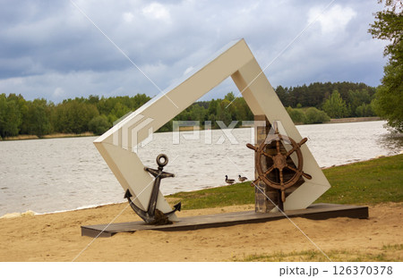 Marine objects -anchor and steering wheel on the beach in the form of a photo zone Marine objects -anchor and steering wheel on the beach in the form of a photo zone 126370378