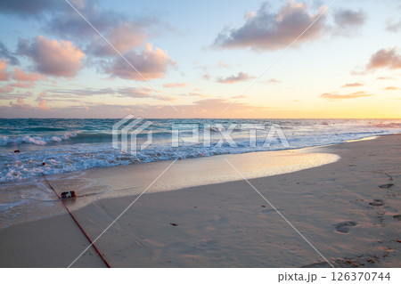 Serene evening view of a sandy shoreline as the sun sets 126370744