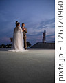Young beautiful couple of newlywed posing in the evening against the background of an atmospheric panorama and stunning sunset 126370960