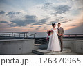 Young beautiful couple of newlywed posing in the evening against the background of an atmospheric panorama and stunning sunset 126370965