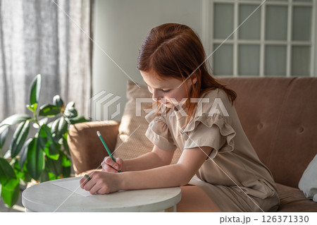 cute little preteen girl drawing with pen while sitting at desk at home, beautiful female child, small kid doing school homework cute little preteen girl drawing with pen while sitting at desk at home, beautiful female child, small kid doing school homework 126371330