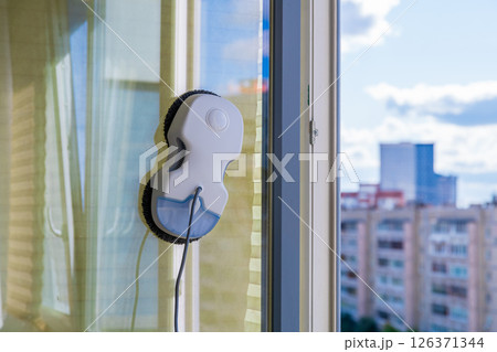 Robot window cleaner washes glass with round rags, robotic service, modern technologies 126371344