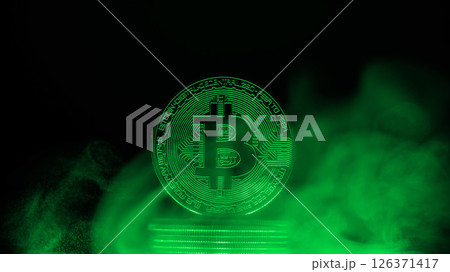 Glowing bitcoin is standing on a stack of coins surrounded by green smoke on a dark background with copy space, representing the mysterious nature of cryptocurrency Glowing bitcoin is standing on a stack of coins surrounded by green smoke on a dark background with copy space, representing the mysterious nature of cryptocurrency 126371417